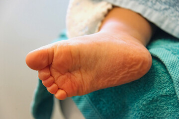 child fresh from bath with towel and foot wrinkled by water