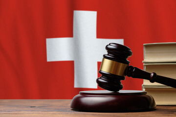 Justice and court concept in Swiss Confederation. Judge hammer on a Switzerland flag background