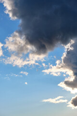 Thunderclouds in the sunny summer blue sky.