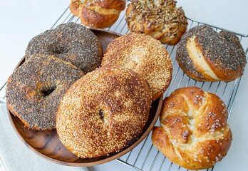 Composition in natural daylight. Homemade buns of various shapes with sesame and poppy seeds. On a metal grill