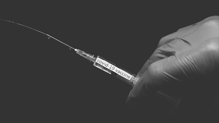 Squeezing the coronavirus vaccine out of a syringe,black and white painting with a cure for...