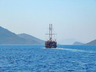 Obraz premium Pirate ship sails the sea, landscape, mountains