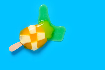 pineapple shape popsicle starts melting on blue background