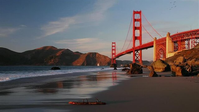 Famous Golden Gate Bridge view from the hidden and secluded rocky Marshall's Beach at sunset in San Francisco, California. High quality FullHD footage
