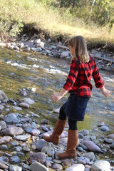 Girl walks on rocks near Rattlesnake Creek Greenough Park Missoula Montana