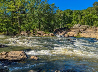 A landscape of a rocky river with bubbly rapids in a North Carolina forest.