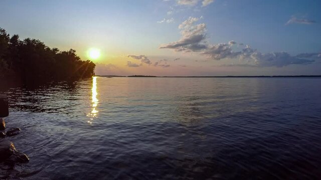 Timelapse from lake level of clouds forming and dissipating as the sun sets.