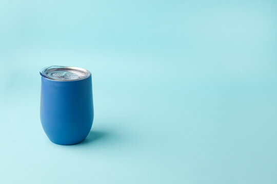 Reusable eco friendly metal cup for take away coffee on blue background. Space for text. Flat lay, top view. Bring your own cup concept. Zero waste, sustainable lifestyle. Mock up.