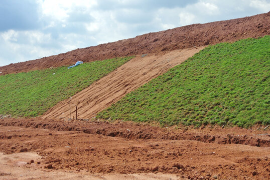 SEREMBAN, MALAYSIA - MARCH 4, 2020: Permanent slope protection using the close turfing method to prevent erosion. The selected type of grass used for this works. The grass also stabilizes the slope st