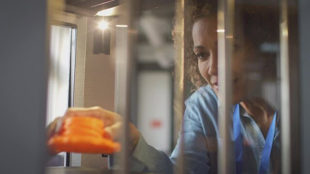 Mature female college student studying engineering using 3D printing machine - shot in slow motion