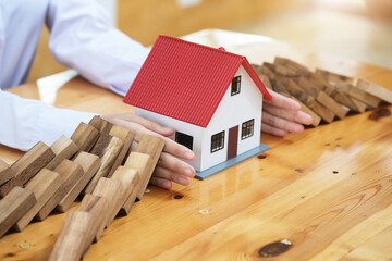 Business risk control Real estate concept,  Businessman protect wooden block fall to planning and...