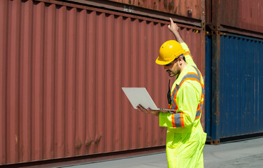 Engineers wear safety reflective clothing with hard hat using laptop for checking and counting steel stock container management in container yard at business logistics site in warehouse.