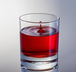 Drop in wine close up. High speed shot. Glass with red wine