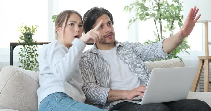 Couple planning and online shopping using laptop at home