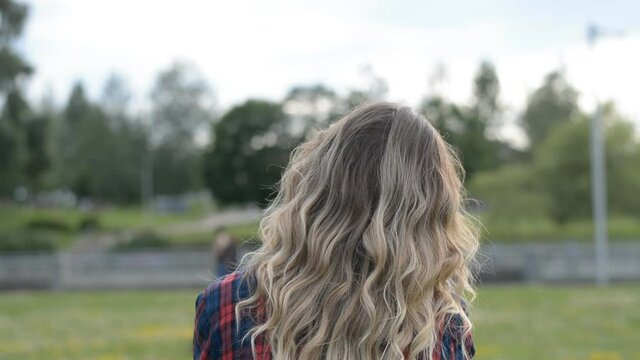 Back view of young blonde woman head in park hd stock footage