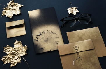 Autumn background . greeting kraft cards mockup template, invitations blank in black, gold colors and fall gold leaves on black textured background. Flat lay, top view, copy space