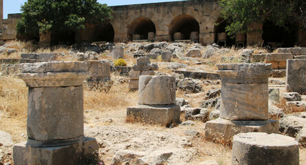 Fototapeta na wymiar Stone bases of statues, the Acropolis of Lindos, Greece. The dedications in Greek glorify the gods