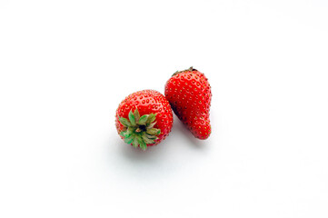 Two strawberries close up on white background