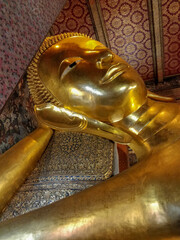 Bangkok, Thailand - January 1st 2020: Famous Reclining Buddha statue gold face. Sleeping Buddha....