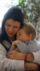 Mother hugging her son on the sofa