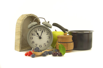 Culinary still life with clock, pot and berries