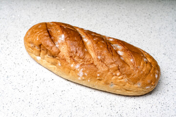 loaf with mold on a light surface. spoiled bread