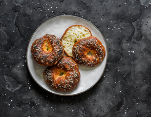 Cheese bagel on a dark background, top view. Delicious breakfast, brunch, snacks