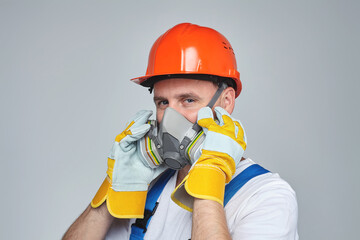 adult male in a construction helmet and a respirator. concept of construction services