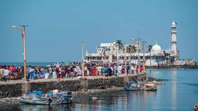 Mumbai, India, daytime time lapse view of worshippers at historical landmark Haji Ali Dargah mosque.