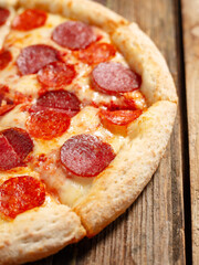 Peperoni pizza on wood background, close up