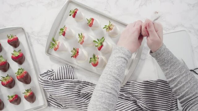 Flat lay. Step by step. Drizzling melted chocolate from pastry piping bag to chocolate covered strawberries.