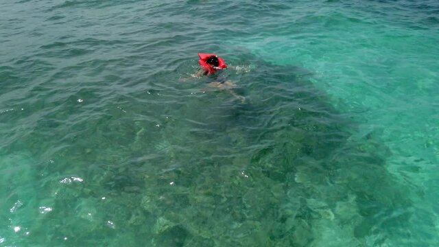 Woman snorkeling in the crystal clear waters of juanillo beach, in cap cana
