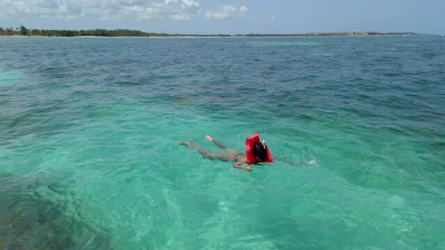 Young woman in the waters of Juanillo Beach snorkeling