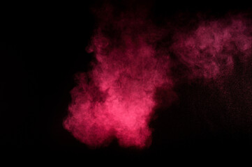 Fototapeta na wymiar Red and pink powder explosion on black background. Colored powder cloud. Colorful dust explode. Paint Holi