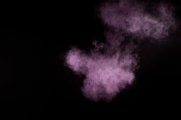 Purple powder explosion on black background. Colored powder cloud. Colorful dust explode. Paint Holi.