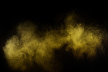 Yellow powder explosion on black background. Colored powder cloud. Colorful dust explode. Paint  Holi.