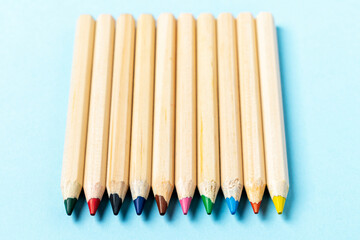 Fototapeta premium Wooden Color pencils on blue background close up with Clipping path.Beautiful color pencils.Color pencils for drawing Rainbow color pencil and used as a background. Top view.