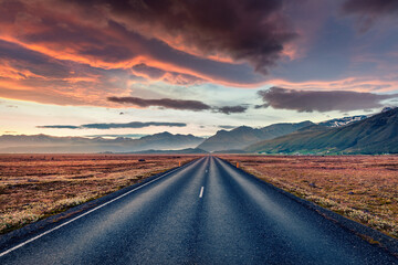 Empty asphalt road with dramatic cloudy sky. Fantastic sunset Iceland. Typical icelandic landscape...