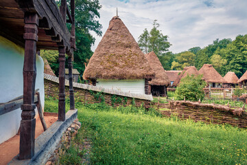 Fototapeta na wymiar Splendid summer view of traditional romanian peasant houses. Beautiful rural scene of Transylvania, Romania, Europe. Traveling concept background..