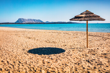 Sunny spring view of empty La Cinta beach with Tavolara island on background. Picturesqaue morning scene of Sardinia island, Italy, Europe. Attractive Mediterranean seascape.