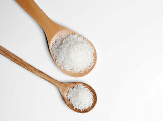 Polished white rice in wooden spoon.