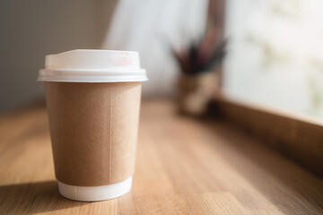 Take away coffee cup with lipstick mark on wooden table in small coffee cafe