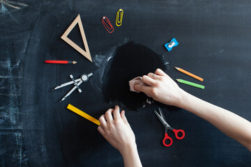 Back to school concept. Chalkboard background. Hand and education tools. 