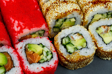 Sushi assorted. Sushi roll with avocado, cucumber. Sushi roll with salmon and caviar. Sushi roll with tuna and caviar. On a light background. Japanese food. View from above
