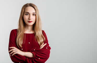 Fototapeta premium Young carefree modern girl with long blonde hairs in casual light clothes posing isolated on white wall background. People lifestyle concept. Copy space for your text