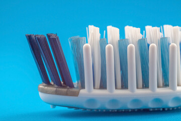 The toothbrush head with massaging bristles close-up on a blue background. Caring for healthy teeth...