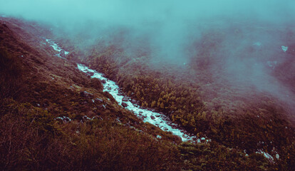 Langtang river below clouds and autumn forest in Langtang National Park in Nepal.