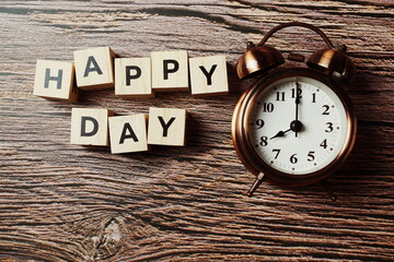 Happy Day with alarm clock on wooden background