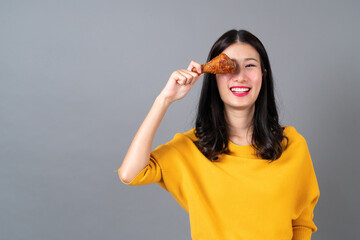 Young asian woman enjoy eating fried chicken drumstick