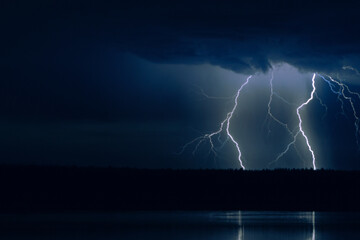 several lightning strikes during a strong thunderstorm over the lake